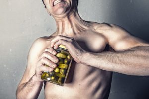 man trying to open a pickle jar